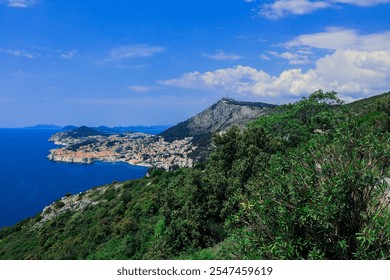 Stunning view of Dubrovnik's coastline and mountains under a clear blue sky during the day showcasing natural beauty and historical architecture - Powered by Shutterstock