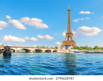 Stunning view of the Eiffel Tower through a historic stone bridge over the Seine river under a cloudy sky on a sunny summer day in Paris, France
