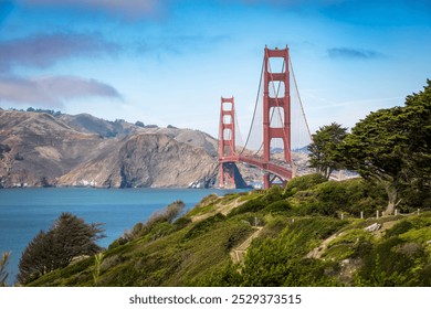 A stunning view of the Golden Gate Bridge surrounded by lush greenery and the calm waters of the San Francisco Bay. - Powered by Shutterstock