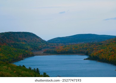 Stunning view of the lake within Porcupine Mountains Wilderness State Park, Michigan, captured from the mountain top, showcasing the vast expanse of water surrounded by dense forest. Ideal for nature  - Powered by Shutterstock