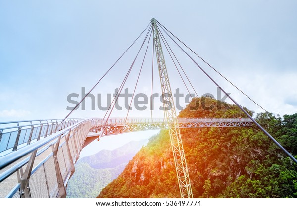 Stunning view of Langkawi sky bridge on\
Mat Cincang mountain. Dark clouds are above the suspension bridge\
and sun light is under the bridge. Travel\
Malaysia