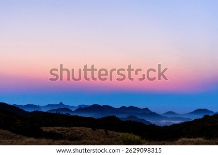A stunning view of layered mountain range during pink and blue colored sunrise