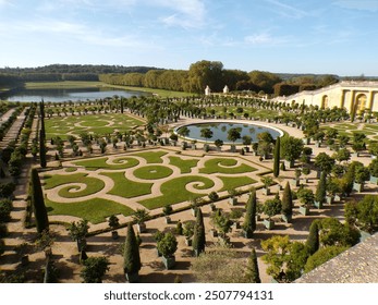 A stunning view of the meticulously landscaped gardens of Versailles, featuring geometric patterns in the neatly trimmed hedges and symmetrical pathways. The formal garden layout includes ornamental t - Powered by Shutterstock