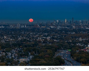 A stunning view of New York City skyline at dusk with a full moon rising over the horizon, capturing the urban landscape and illuminated highways. - Powered by Shutterstock