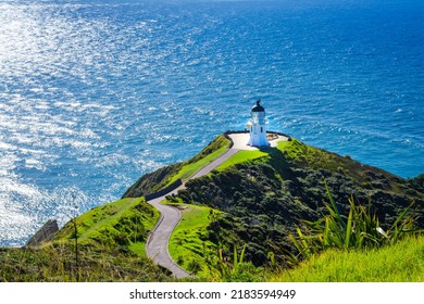 Stunning view over Cape Reinga Lighthouse and a winding path leading to it. Famous tourist attraction at Cape Reinga, the northernmost point of of New Zealand.