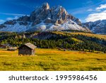 Stunning view of Peitlerkofel mountain from Passo delle Erbe in Dolomites, Italy. View of Sass de Putia (Peitlerkofel) at Passo delle Erbe, with wooden farm houses, Dolomites, South Tyrol, Italy.