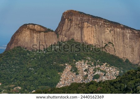 Stunning view of Rocinha, the largest favela in South America, with Dois Irmaos rocks and clear sky in the background.
