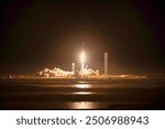 A stunning view of a space shuttle launch at night, with the rocket blazing through the atmosphere and leaving a trail of smoke and fire. The city lights . Elements of this image furnished by NASA