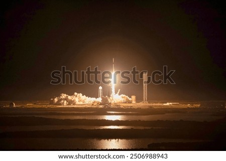 A stunning view of a space shuttle launch at night, with the rocket blazing through the atmosphere and leaving a trail of smoke and fire. The city lights . Elements of this image furnished by NASA