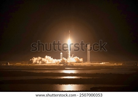 A stunning view of a space shuttle launch at night, with fiery flames and smoke billowing into the dark sky. The reflection of the launch in the calm lake. Elements of this image furnished by NASA