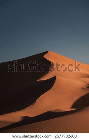 Stunning view of the sun setting over the erg chebbi dunes in the sahara desert, near the village of merzouga, morocco