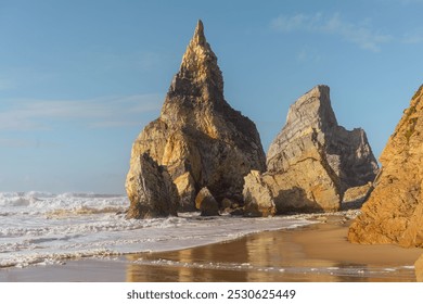 A stunning view of towering rock formations on a serene beach, illuminated by warm sunlight. The ocean waves gently lap the sandy shore, creating a peaceful and inspiring coastal scene. - Powered by Shutterstock