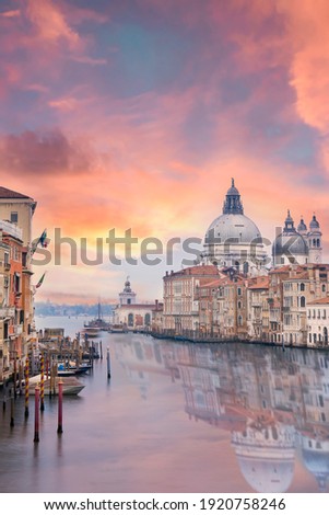Stunning view of the Venice skyline with the Grand Canal and Basilica Santa Maria Della Salute in the distance during a dramatic sunrise. Picture taken from Ponte Dell’ Accademia, Venice, Italy.