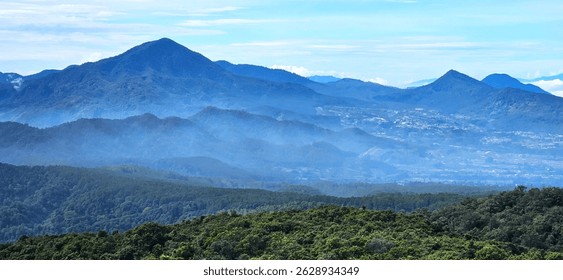 Stunning West Java mountain landscape with lush green hills, and soft mist embracing the peaks —perfect for tourism content, creative backgrounds, or viral nature adventure inspiration.