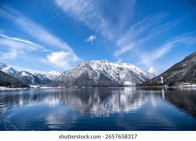 Stunning Winter Alpine Lake Reflection: Snow-Capped Mountains, Blue Sky and Village Scenery – Pristine Nature Landscape