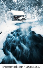 Stunning Winter Landscape View Of Snow Covered Hut By River In Oulanka National Park In Lapland Finland