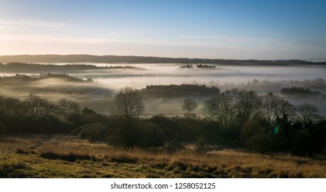 Stunning winter morning scene at Newland's Corner in the North Downs with fog in the valley. Countryside landscape in the Surrey Hills Area of Natural Beauty, UK.