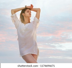 Stunning Young Sexy Brunette Woman In White Blous And Bare Legs Elegant Posing Over Sky.
