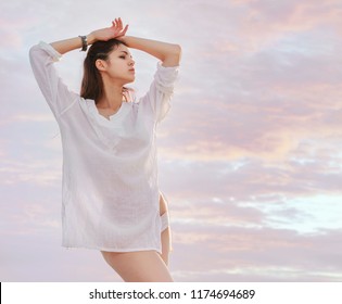 Stunning Young Sexy Brunette Woman In White Blous And Bare Legs Elegant Posing Over Sky.