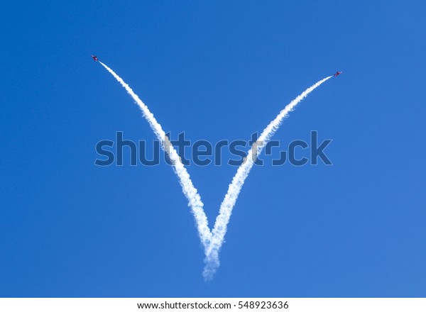 Stunt\
jets leaving a white smoke trail making a\
heart