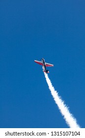 Stunt plane in a steep climb against a clear blue sky at Avalon air show with a smoke trail - Shutterstock ID 1315107104
