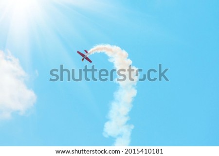 Similar – Red plane with propeller flying upward with white smoke