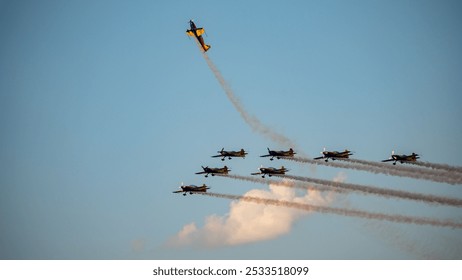 Stunt planes performing acrobatic maneuvers against a clear blue sky - Powered by Shutterstock