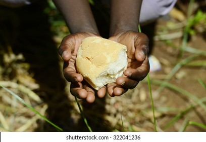     Stunting African Children Symbol - Baby Girl Holding Bread Malnutrition. Starving Hunger Symbol. Black African Girl Holding Bread As A Malnutrition Symbol. 