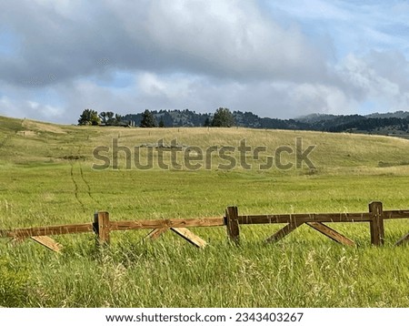 Sturdy wooden fence between public space and private property beyond.  Stormy cloudy sky.