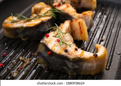 Sturgeon steaks on the grill with spices and herbs. Closeup