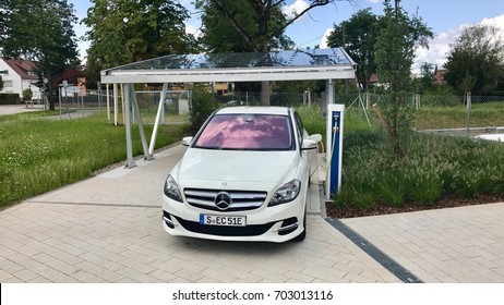 Stuttgart - August 20, 2017: A Merceds B-CLass electric car is being charged in front of a carport covered with solar panels - concept for future sustainable and self-contained mobility