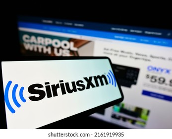 Stuttgart, Germany - 02-13-2022: Cellphone with logo of American broadcasting company Sirius XM Holdings Inc. on screen in front of website. Focus on left of phone display. Unmodified photo.