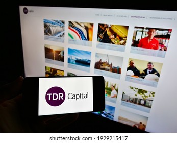 Stuttgart, Germany - 02-25-2021: Person Holding Mobile Phone With Business Logo Of British Investment Company TDR Capital LLP On Screen In Front Of Website. Focus On Phone Display. Unmodified Photo.