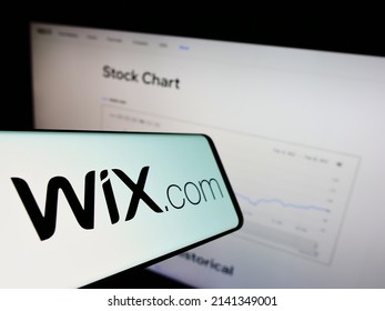 Stuttgart, Germany - 03-01-2022: Smartphone with logo of Israeli software company Wix.com Ltd. on screen in front of business website. Focus on center of phone display. Unmodified photo.