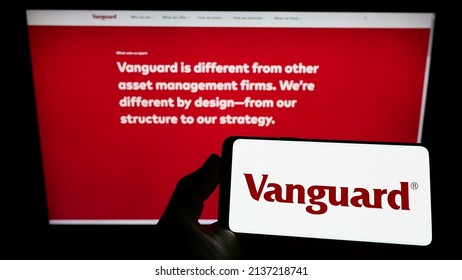 Stuttgart, Germany - 03-12-2022: Person holding smartphone with logo of US financial company The Vanguard Group Inc. on screen in front of website. Focus on phone display. Unmodified photo.
