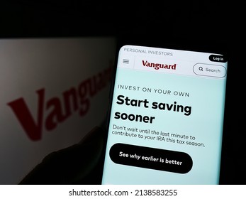 Stuttgart, Germany - 03-12-2022: Person holding cellphone with webpage of US financial company The Vanguard Group Inc. on screen in front of logo. Focus on center of phone display. Unmodified photo.