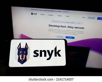 Stuttgart, Germany - 03-12-2022: Person Holding Smartphone With Logo Of US Cybersecurity Company Snyk Limited On Screen In Front Of Website. Focus On Phone Display. Unmodified Photo.