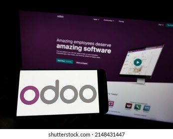 Stuttgart, Germany - 03-29-2022: Person holding cellphone with logo of French software company Odoo SA on screen in front of business webpage. Focus on phone display. Unmodified photo.