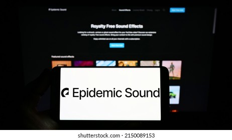 Stuttgart, Germany - 03-30-2022: Person Holding Smartphone With Logo Of Swedish Music Company Epidemic Sound AB On Screen In Front Of Website. Focus On Phone Display. Unmodified Photo.