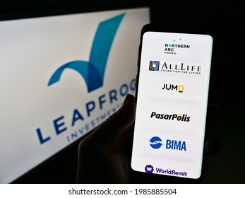 Stuttgart, Germany - 05-21-2021: Person holding mobile phone with webpage of private equity firm LeapFrog Investments on screen in front of logo. Focus on center of phone display. Unmodified photo.