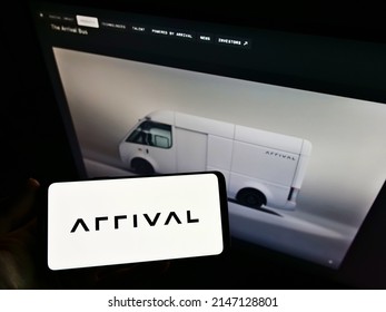 Stuttgart, Germany - 05-21-2021: Person Holding Smartphone With Logo Of Electric Vehicle Manufacturer Arrival Ltd. On Screen In Front Of Website. Focus On Phone Display. Unmodified Photo.