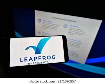 Stuttgart, Germany - 05-21-2021: Person holding smartphone with logo of private equity firm LeapFrog Investments on screen in front of website. Focus on phone display. Unmodified photo.