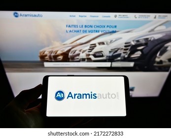 Stuttgart, Germany - 05-21-2021: Person Holding Smartphone With Logo Of French Online Car Dealer Aramis SAS (Aramisauto) On Screen In Front Of Website. Focus On Phone Display. Unmodified Photo.