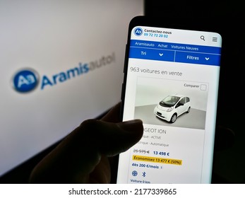 Stuttgart, Germany - 05-21-2021: Person Holding Cellphone With Website Of French Online Car Dealer Aramis (Aramisauto) On Screen In Front Of Logo. Focus On Center Of Phone Display. Unmodified Photo.