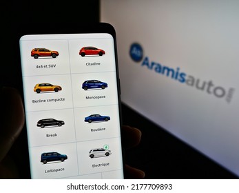 Stuttgart, Germany - 05-21-2021: Person Holding Smartphone With Webpage Of French Online Car Dealer Aramis SAS (Aramisauto) On Screen With Logo. Focus On Center Of Phone Display. Unmodified Photo.