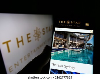 Stuttgart, Germany - 05-21-2022: Person Holding Cellphone With Webpage Of Company The Star Entertainment Group Limited On Screen With Logo. Focus On Center Of Phone Display. Unmodified Photo.