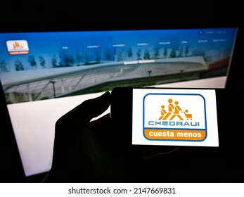 Stuttgart, Germany - 05-22-2021: Person Holding Cellphone With Logo Of Mexican Retail Company Grupo Comercial Chedraui On Screen In Front Of Business Website. Focus On Phone Display. Unmodified Photo.