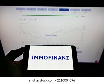 Stuttgart, Germany - 05-24-2021: Person Holding Smartphone With Logo Of Austrian Real Estate Investment Company Immofinanz AG On Screen In Front Of Website. Focus On Phone Display. Unmodified Photo.