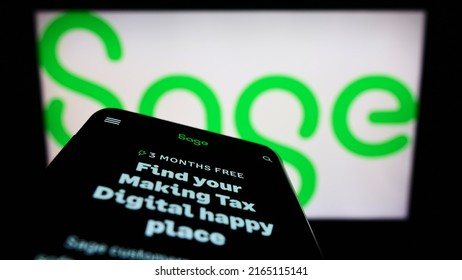 Stuttgart, Germany - 05-29-2022: Mobile phone with website of British software company The Sage Group plc on screen in front of business logo. Focus on top-left of phone display. Unmodified photo.