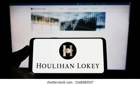 Stuttgart, Germany - 06-12-2022: Person Holding Smartphone With Logo Of US Investment Company Houlihan Lokey Inc. On Screen In Front Of Website. Focus On Phone Display. Unmodified Photo.